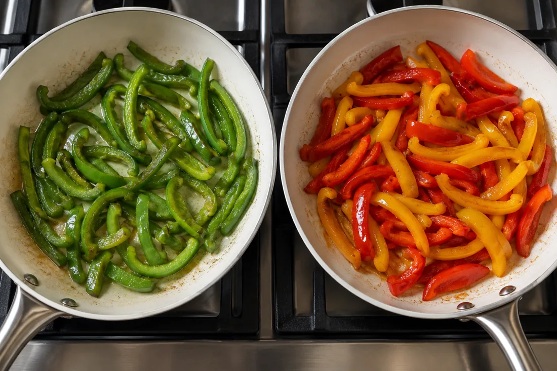 Green pepper strips and colored pepper strips cooking in separate pans